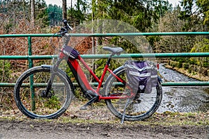 winter bicycle trip in the mountains by the river, electric bike with panniers