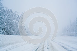 Winter blizzard in the driving north empty road landscape with white trees and snow with fog in the background. Road