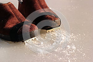 Winter boots with affixed ice cleats photo