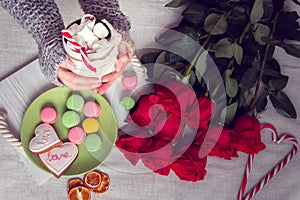 Winter breakfast in bed with red roses and heart of striped lollipop