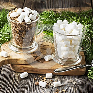 Winter breakfast ingredients. Chocolate oat cereal with marshmallows in portioned glass mugs