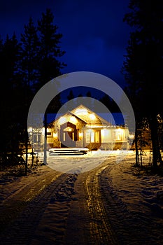 Winter Cabin Glowing Warm at Night Blue Sky