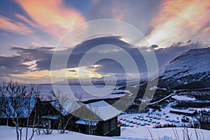 Winter cabins in Abisko in Sweden, with a view over a frozen lake