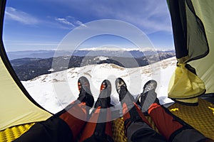 Winter camping in the mountains with a backpack and tent.