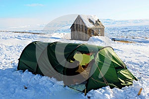Winter camping - Tent with an old house on the East Coast of Greenland near to Ittoqqortoormiit photo
