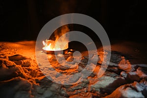 Winter campsite fire burning at night