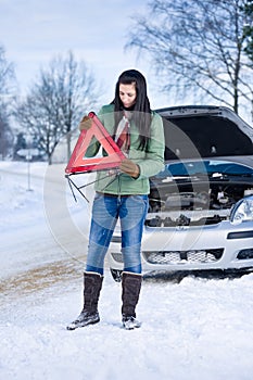 Winter car breakdown - woman warning triangle