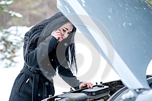 Winter car breakdown - young beautiful woman call for help, road