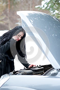 Winter car breakdown - young beautiful woman call for help, road