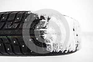 winter car tire on snow at shallow depth of field