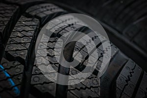 Winter car tires in row isolated on black