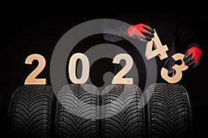 car tire services maintance replace wheels and mechanic hands 2024 new year black background