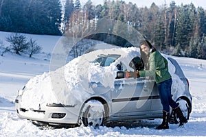 Winter car - woman remove snow from windshield photo