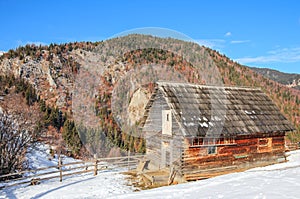 Winter in the Carpathian mountains with a wooden cabin in the foreground