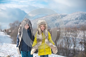 Winter children. Adorable little girl and boy having fun on snowy day on snow landscape. Brother and sister. Portrait of