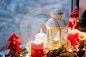 Winter Christmas holidays background with candles; christmas light; Cup of cocoa with marshmallow or hot chocolate near a window