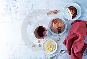 Winter Christmas holidays background with Cup of tea and wool scarf, cinnamon bun roll and snowman