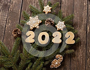 Winter Christmas home baked cookies decorating a Christmas tree on wooden background wishing you a happy New Year 2022