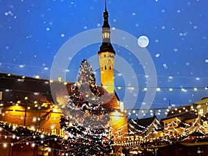 Winter Christmas  tree holiday in Tallinn old town square night city blurring light and snowflakes fall