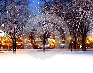 Winter city ,evening park, buildings blurred light ,trees covered by snow, Chon ,snowfall,people walk on snowy street in medieval