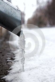 Winter city fragment. Icicles and frost on drainpipe