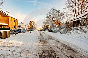 Winter cityscape, snow covered sidewalk and melting snow street