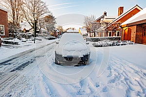 Winter cityscape with an urban street, sidewalks and a car covered by thick layer of snow