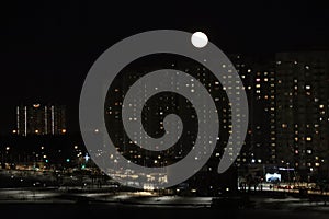 winter cloudless night view of the city - full moon over high-rise buildings