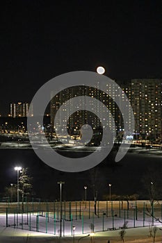 winter cloudless night view of the city - full moon over high-rise buildings
