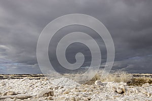 Winter coastal seascape with floating ice fragments on still cold water. Baltic Sea