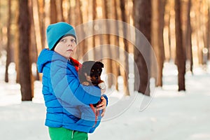 In the winter cold day warms boy puppy