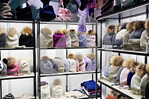 Winter colorful hats with fur pompom in shop