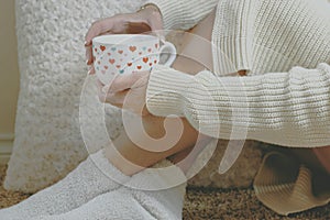 Winter is coming. Cozy at home with warm socks and a hot tea in a mug