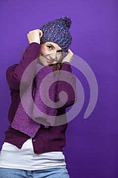 Winter Concepts. Positive Cute Caucasian Adult Female Woman In Warm Knitted Hat and Violet Scarf Posing with Lifted Hands And