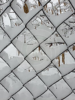 winter at countryside - wire-mesh fence covered by snow
