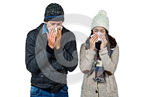 Winter couple blowing their noses