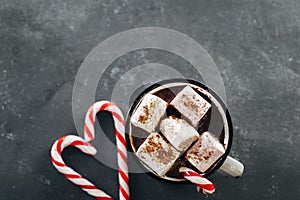 Winter cozy beverage. Glass with hot chocolate with marshmallow on dark blue background