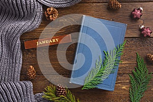 Winter, cozy composition. Warm plaid, book and christmas decoration, on wooden background