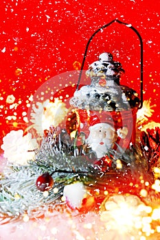 Winter cozy concept with clay lantern Santa Claus, Christmas decor on snow background. Red blured bokeh
