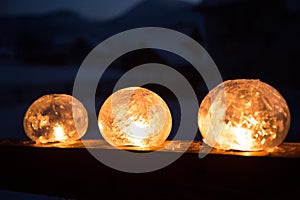 Winter craft: Ice lanterns with flickering fire of a candle