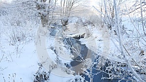 Winter creek in the forest snow, frozen branches of trees landscape nature