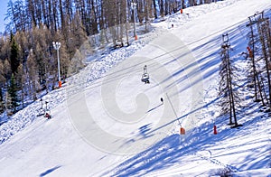 Winter day on a ski resort in Europe. Beautiful texture created by skiers descending the mountain. Ski lift on the slop