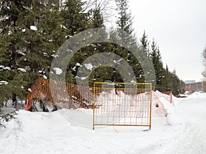 Winter day. Trees under the snow. Nature in the city. Urban environment. After a snowfall. Fences