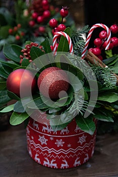 Winter decor. Beautiful arrangement of natural spruce twigs, red balls, lollipops for indoor outdoor festive decorating