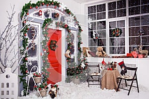 Winter decoration. Red door with Christmas wreath