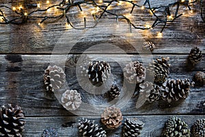 Winter decorative light on rustic wooden timbers with fir cones