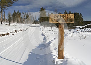 Winter dirt road in Siberia with an inscription in Cyrillic \