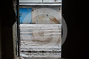 Winter dirty broken road in a garage cooperative. Gray depressing moody winter