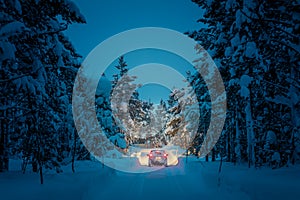 Winter Driving at night - Lights of car in snowy road