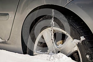 Winter driving problems, snow and ice. Extreme winter series. Huge icicles on the dirty car wheel. Dangerous ice build up car